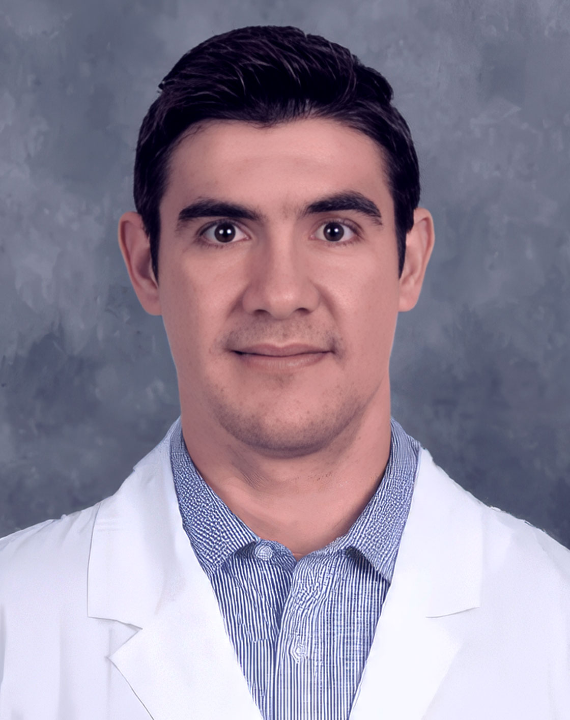 Man in white coat posing for portrait.