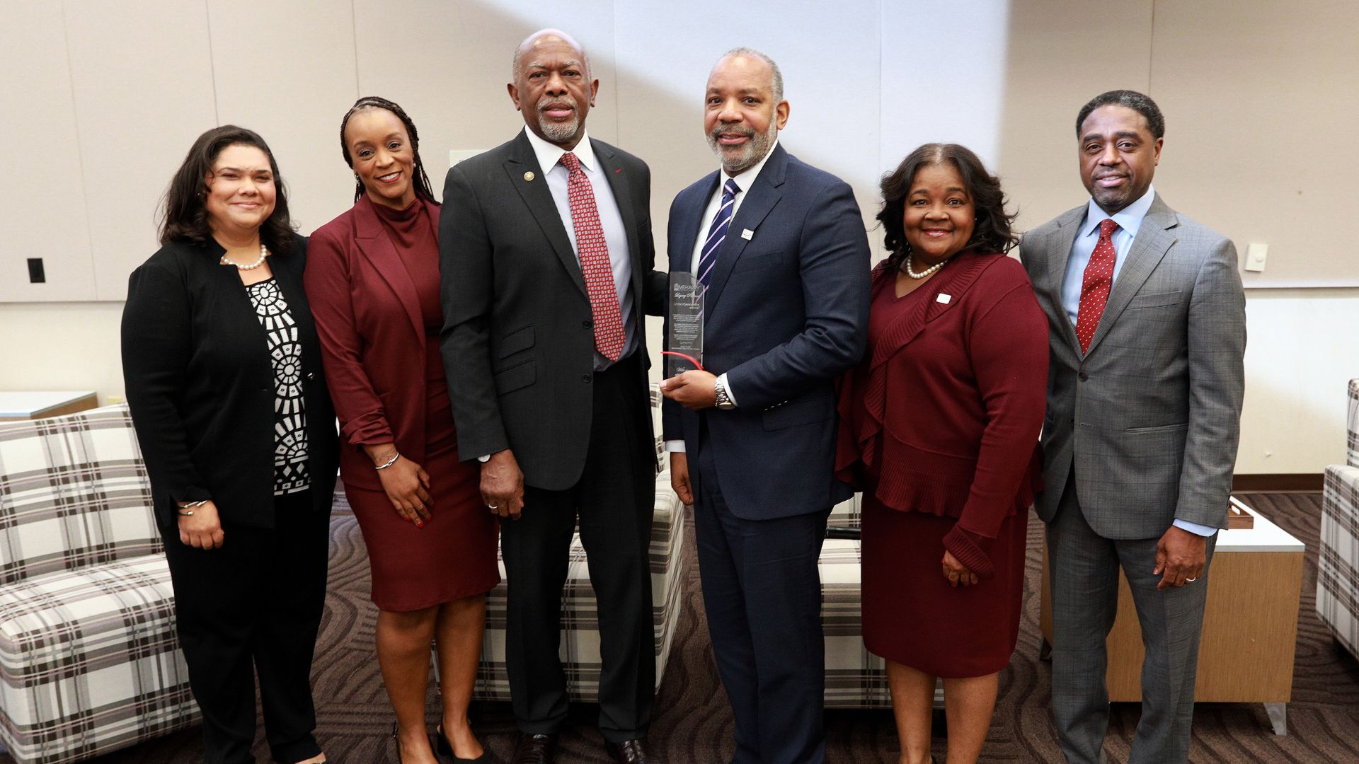 Group smiling while accepting an award.