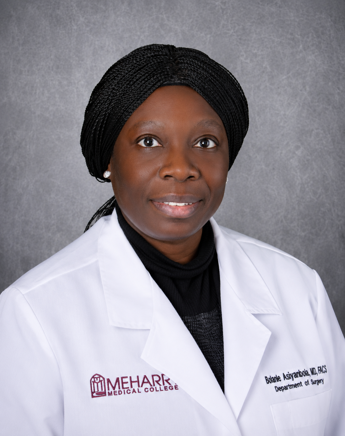 Woman wearing white coat posing for portrait.